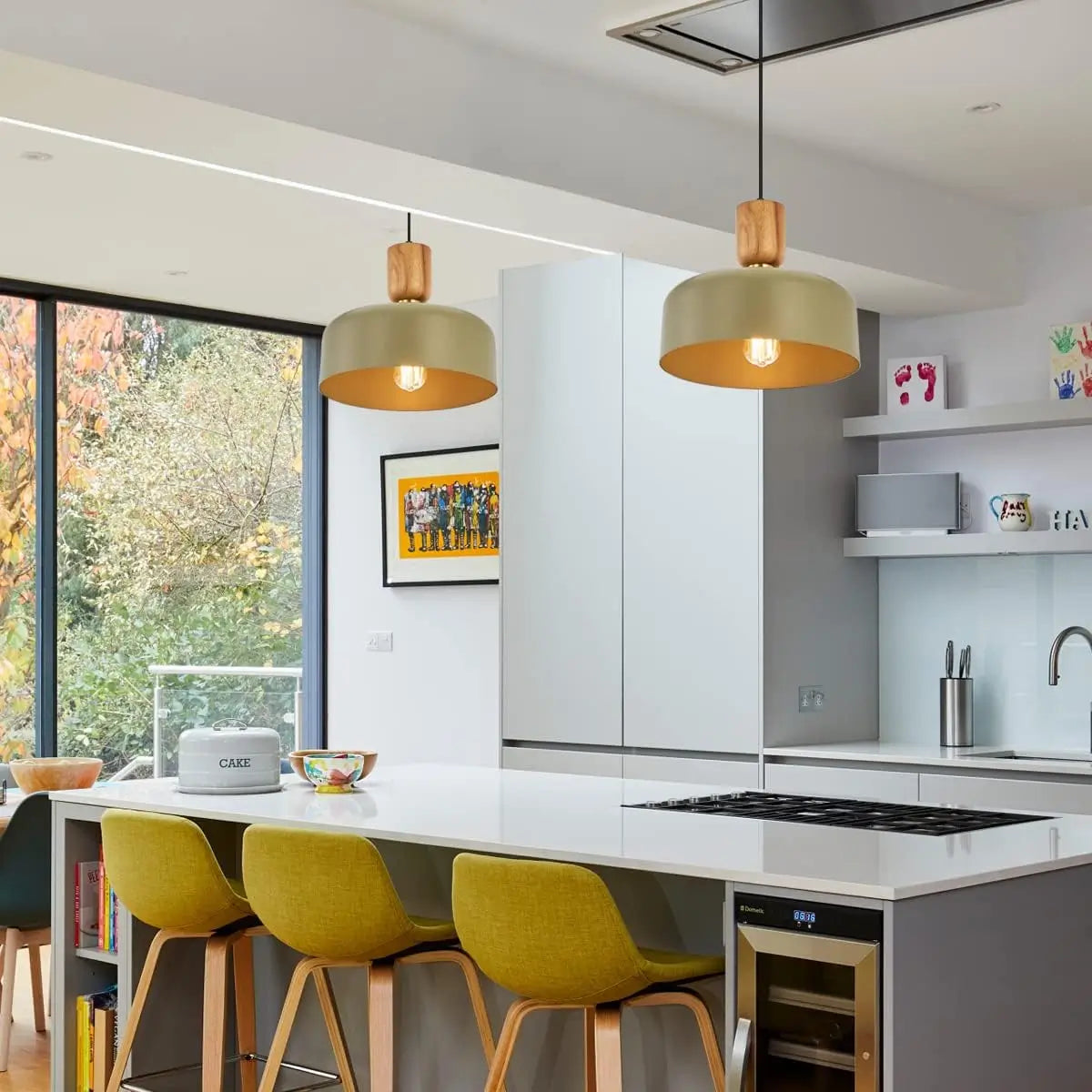Twin pendant lights hanging above a modern kitchen island with yellow stools