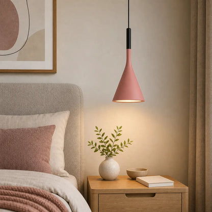 Pink cone pendant light used above a wood nightstand beside an upholstered bed.