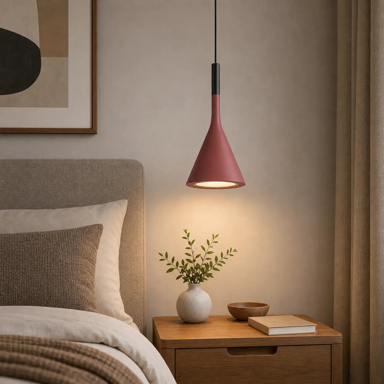 Red cone pendant light providing downward light above a wood nightstand beside an upholstered bed.