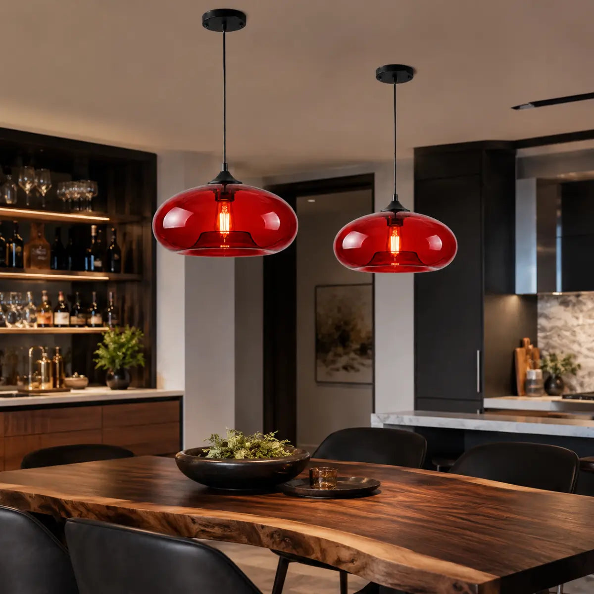 Two red oval glass pendant lights hanging above a live-edge dining table in a modern kitchen.