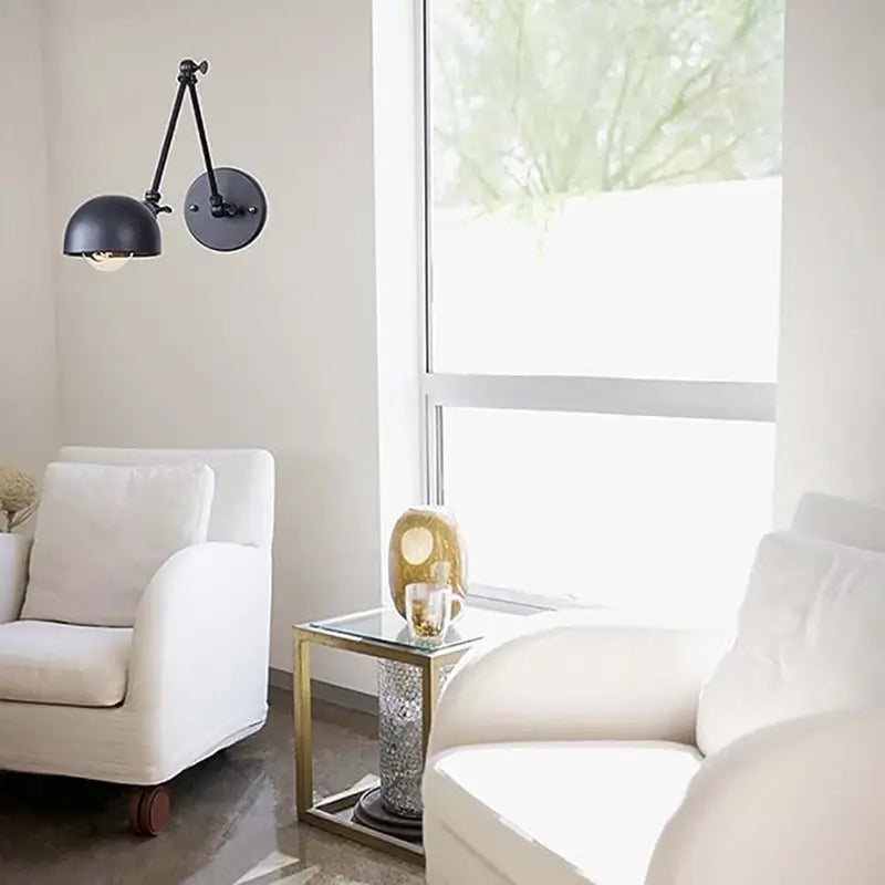 Vintage wall-mounted reading light in a modern minimalist interior, positioned beside a white armchair for cozy lighting.