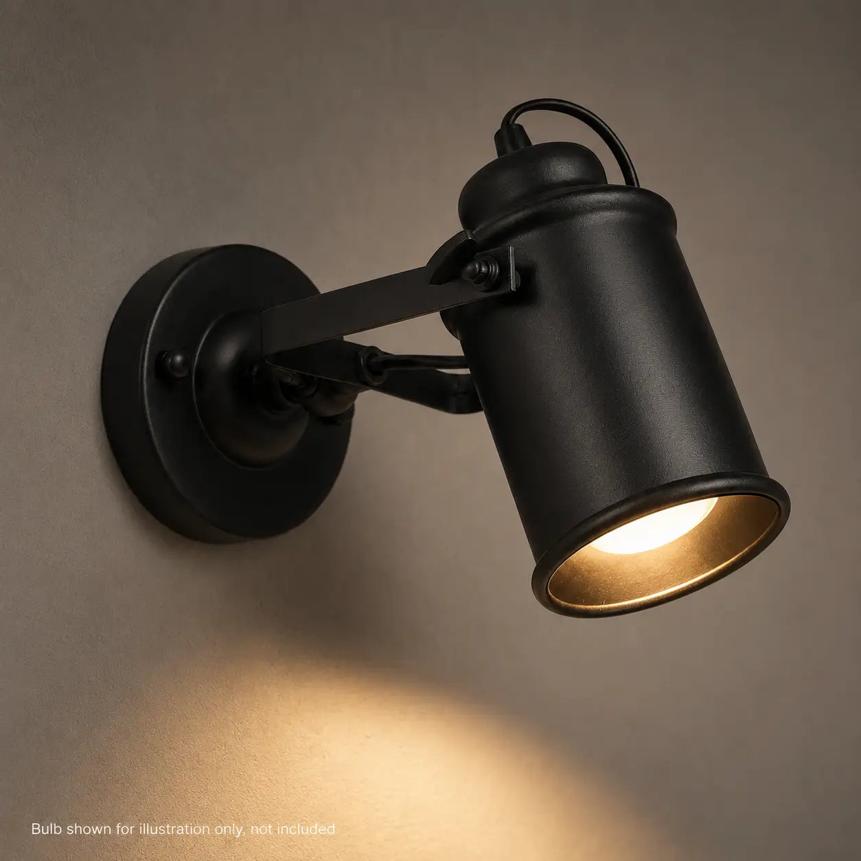Close-up of illuminated matte black wall sconce showing bulb glow