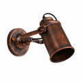 Industrial wall sconce with weathered copper finish and adjustable cylindrical shade