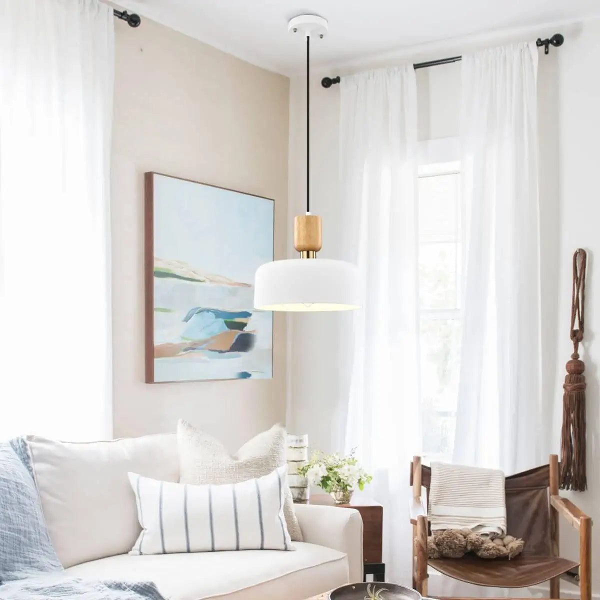 Matte white pendant light over cozy living space with soft furnishings and natural light.