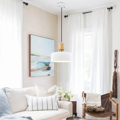Matte white pendant light over cozy living space with soft furnishings and natural light.